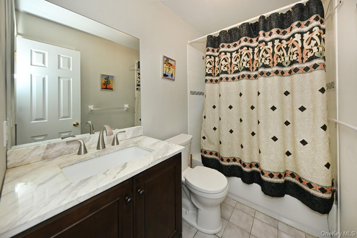 14 Roble Road Suffern, NY 10901 - Photo 19 of 30 Bathroom featuring vanity, shower / tub combo with curtain, and tile patterned flooring