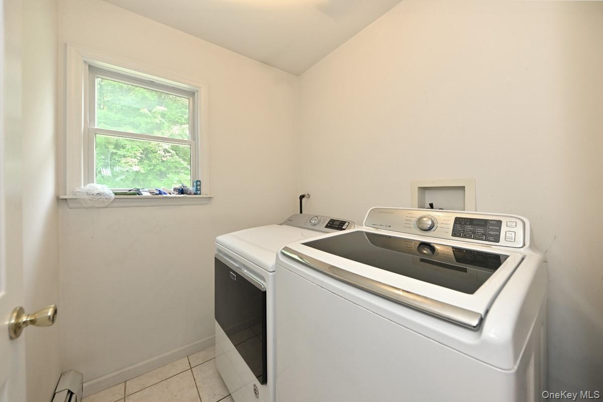 14 Roble Road Suffern, NY 10901 - Photo 25 of 30 Laundry room featuring independent washer and dryer, light tile patterned floors, and baseboard heating