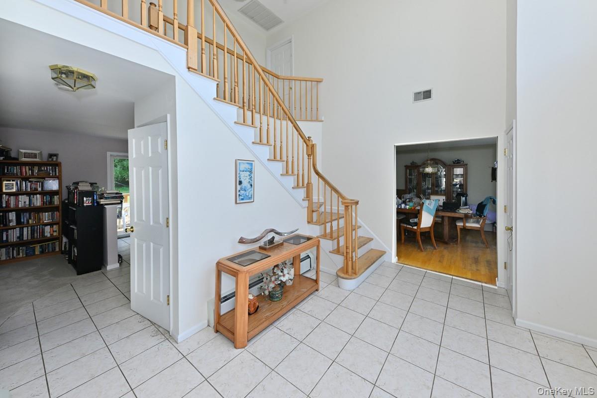 14 Roble Road Suffern, NY 10901 - Photo 8 of 30 Entrance foyer featuring light tile patterned floors, stairs, and a towering ceiling