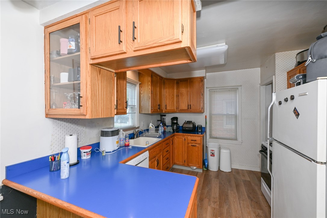 4166 Verona Road Cleveland, OH 44121 - Photo 7 of 43 Kitchen with white fridge, dark hardwood / wood-style flooring, sink, and kitchen peninsula