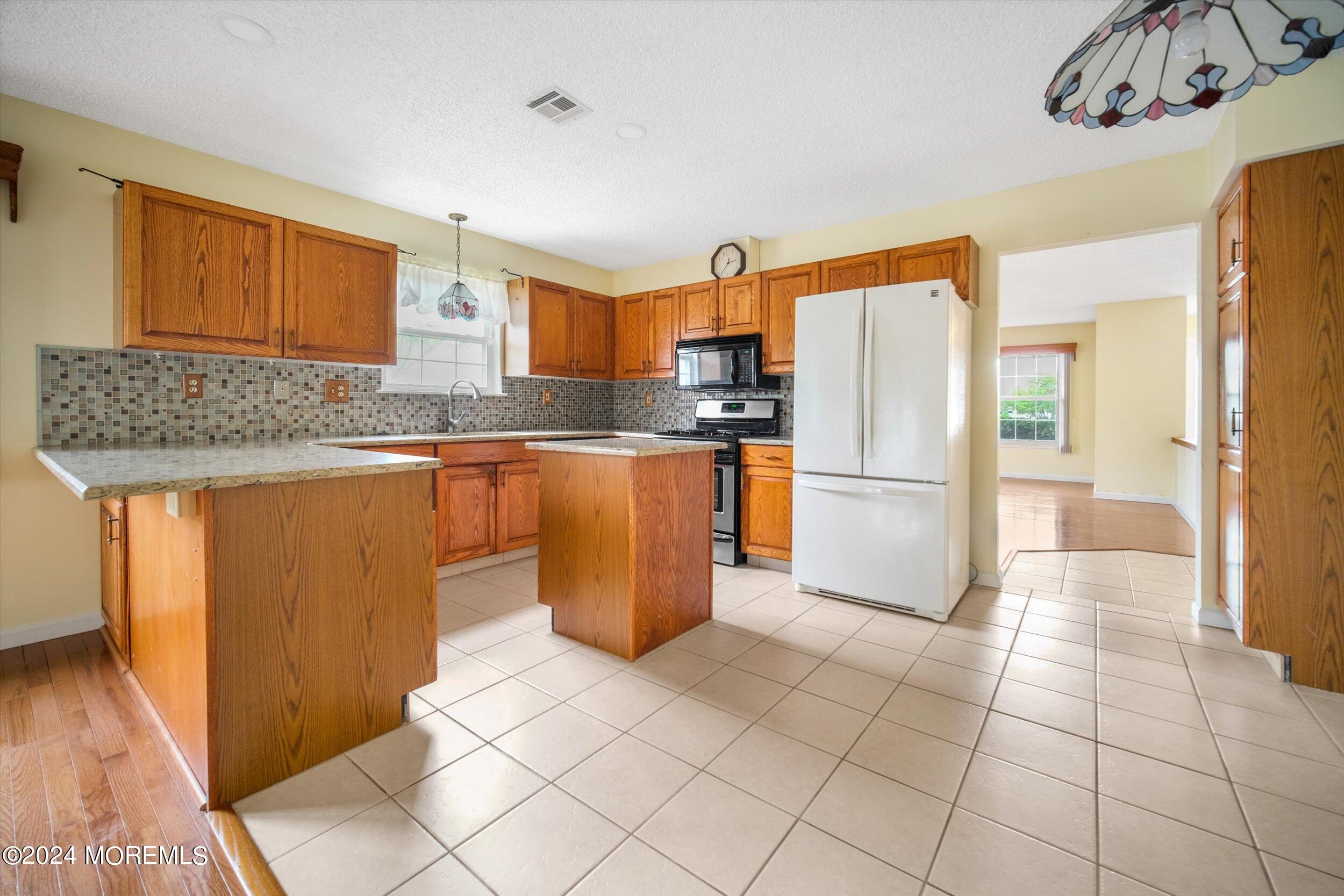 1 Lambert Way Toms River, NJ 08757 - Photo 14 of 26 a kitchen with stainless steel appliances granite countertop a refrigerator a stove top oven and a sink