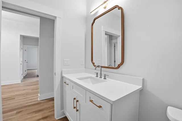 a view of an empty room with window and wooden floor