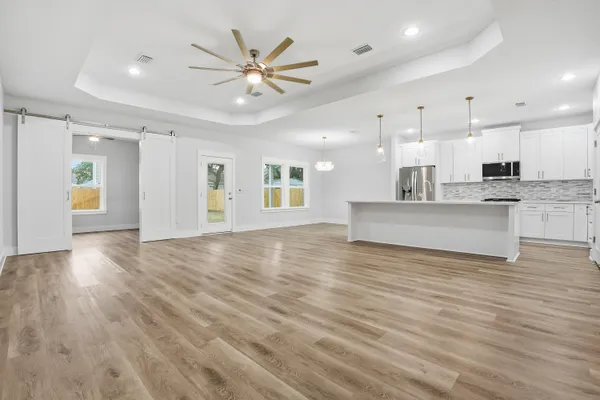 a view of an empty room with window and wooden floor