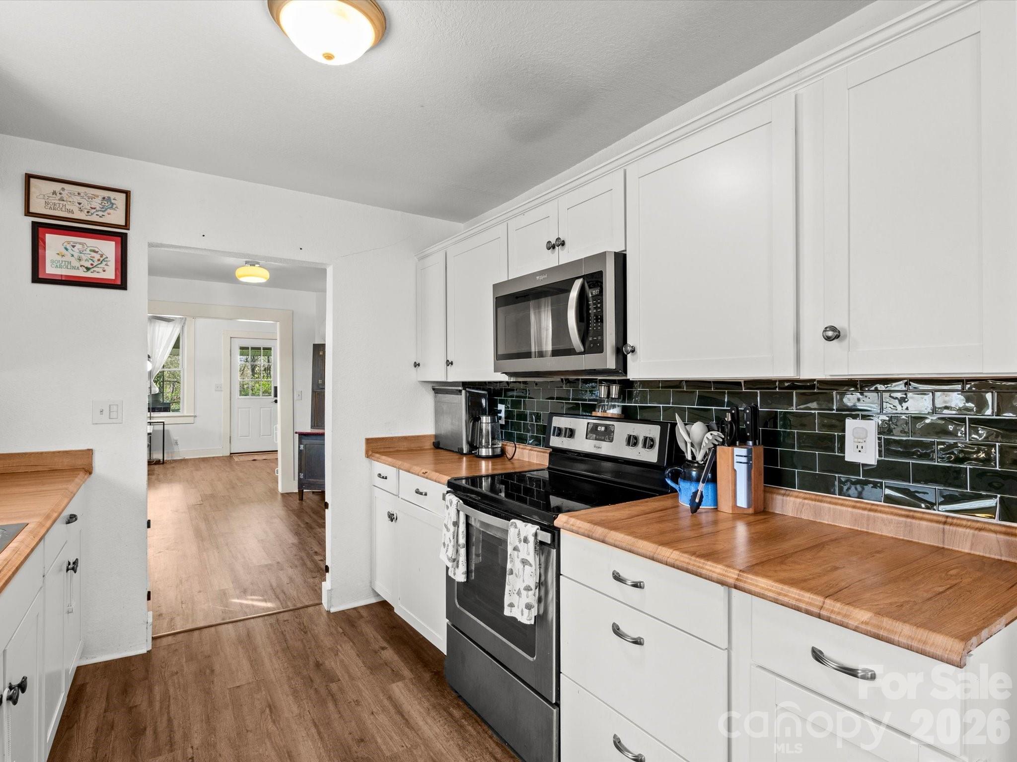 12 Maple Lane Arden, NC 28704 - Photo 24 of 31 a kitchen with stainless steel appliances a sink dishwasher stove microwave and cabinets with wooden floor