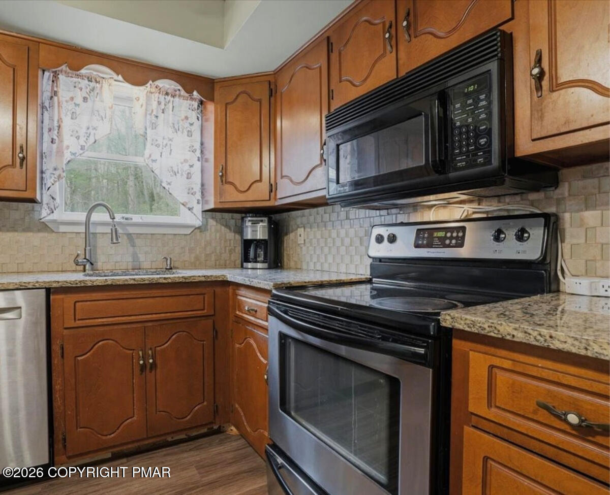 239 Sundance Road Effort, PA 18330 - Photo 12 of 60 a kitchen with stainless steel appliances granite countertop a stove microwave and sink