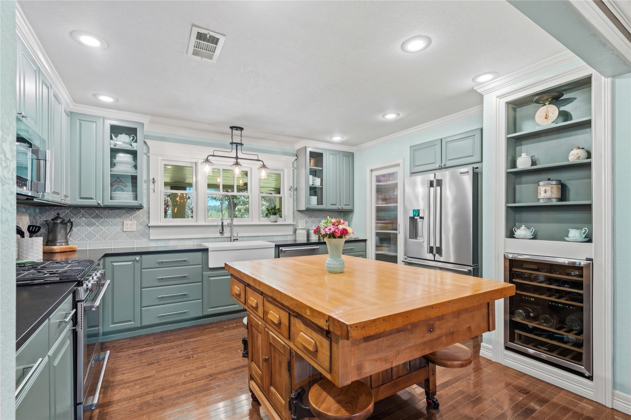 17821 Brown Road Conroe, TX 77306 - Photo 16 of 50 a kitchen with a refrigerator a stove a sink and a dining table with wooden floor