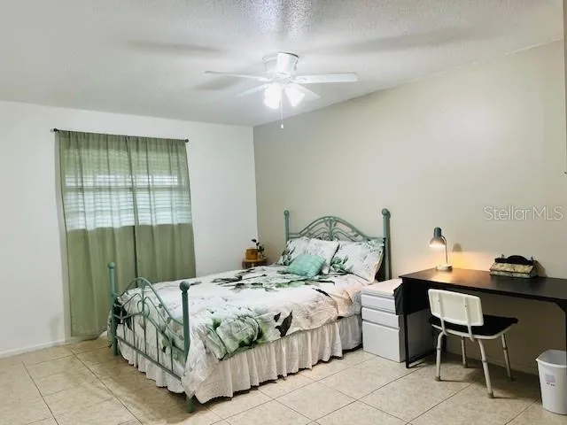 a bedroom with a bed table and chair