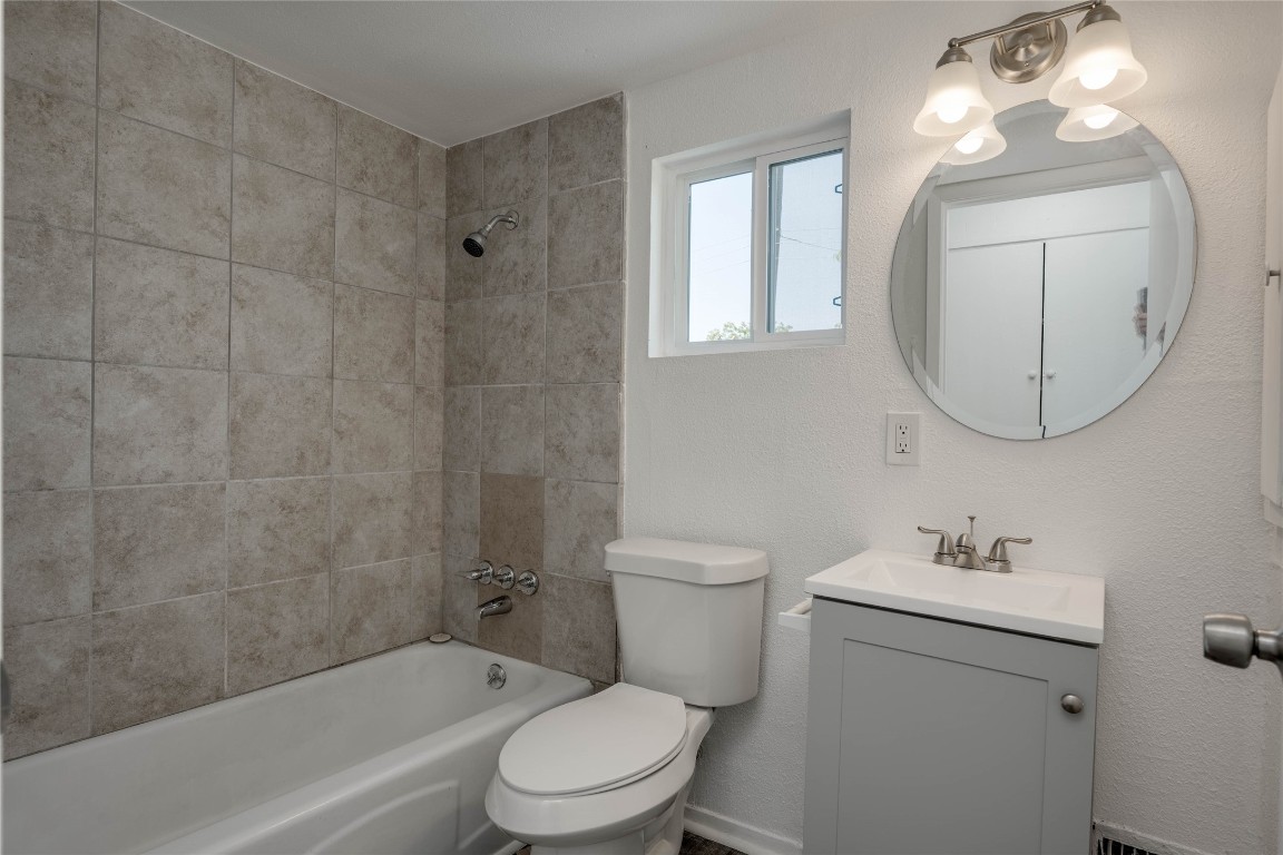 1303 East St Johns Avenue Austin, TX 78752 - Photo 22 of 30 a bathroom with a toilet a sink a mirror and bathtub