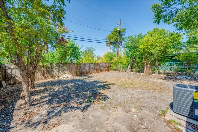 a view of a house with a yard and large tree