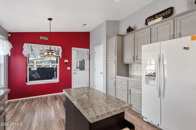 a kitchen with stainless steel appliances granite countertop a refrigerator and a stove top oven