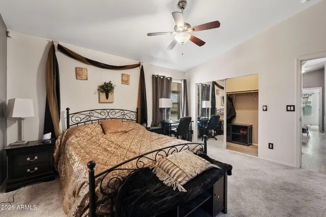 a bedroom with a large bed and a chandelier