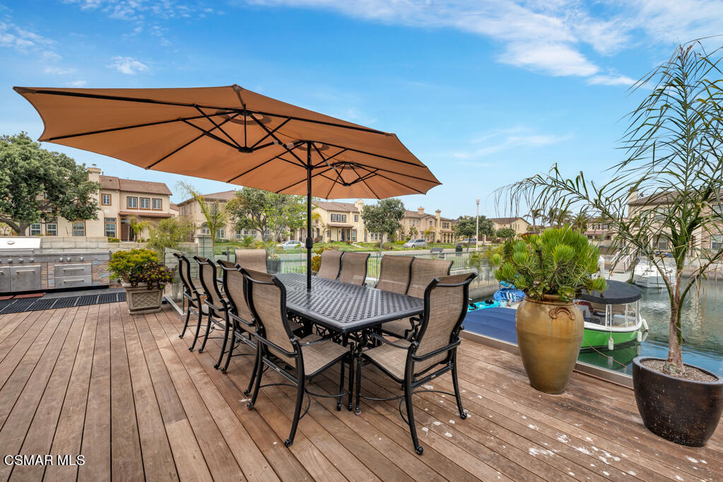 1410 Viewpoint Drive Oxnard, CA 93035 - Photo 56 of 73 a view of a patio with table and chairs under an umbrella with wooden floor