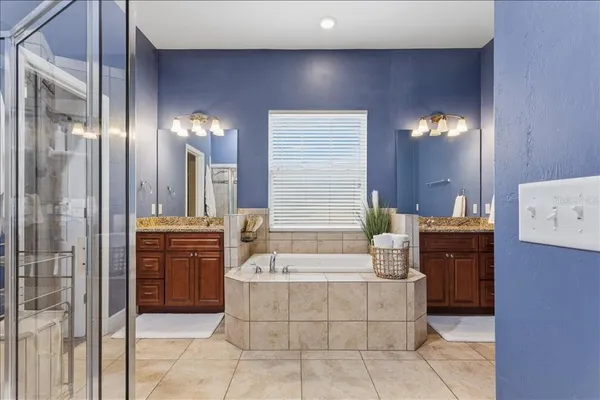 a spacious bathroom with a bathtub sink and mirror