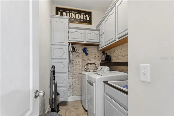a bedroom with a bed a couch and a chandelier