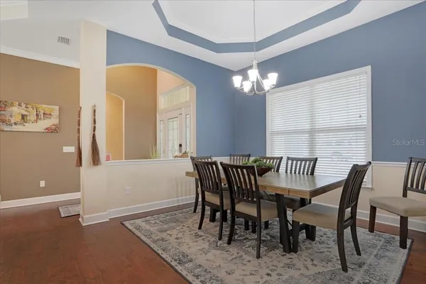 a view of a dining room with furniture and chandelier