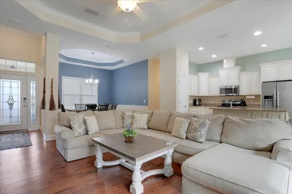 a living room with furniture and a view of kitchen