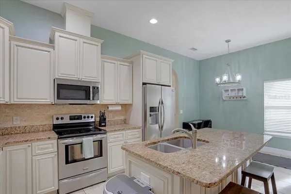 a kitchen with granite countertop a sink stove and refrigerator