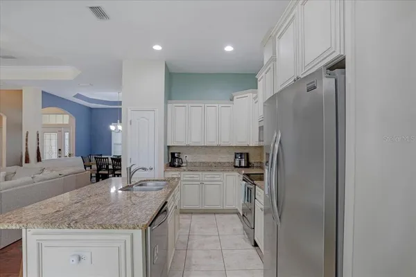 a kitchen with a refrigerator sink and cabinets