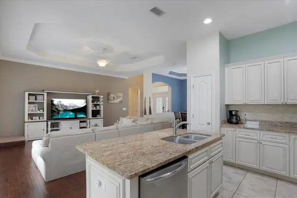 a kitchen with stainless steel appliances granite countertop a sink a stove and a wooden cabinets