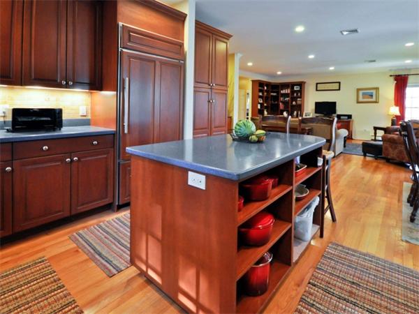 19 Colonial Road Needham, MA 02492 - Photo 6 of 30 a kitchen with stainless steel appliances granite countertop a table chairs in it and wooden floors