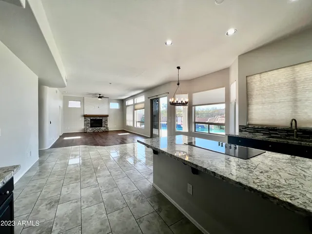 a view of open kitchen with granite countertop a stove and a sink