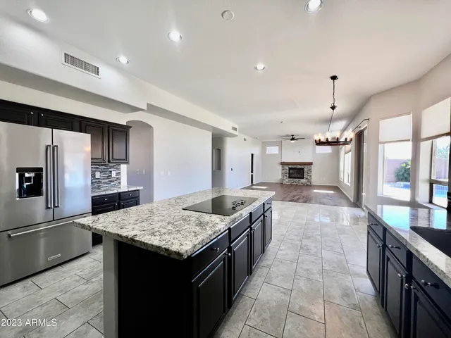 a view of kitchen with stainless steel appliances kitchen island wooden floor and living room view
