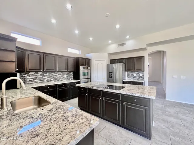 a view of a living room and kitchen with furniture wooden floor and windows