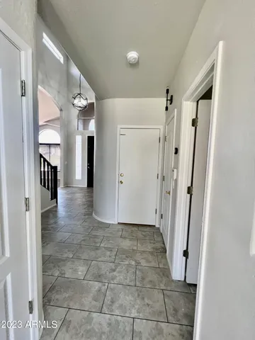a view of a hallway with entryway and wooden floor