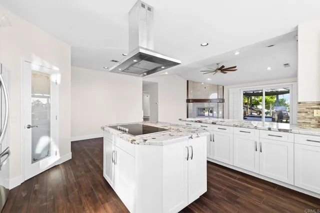 a kitchen with stainless steel appliances kitchen island granite countertop a stove and a refrigerator