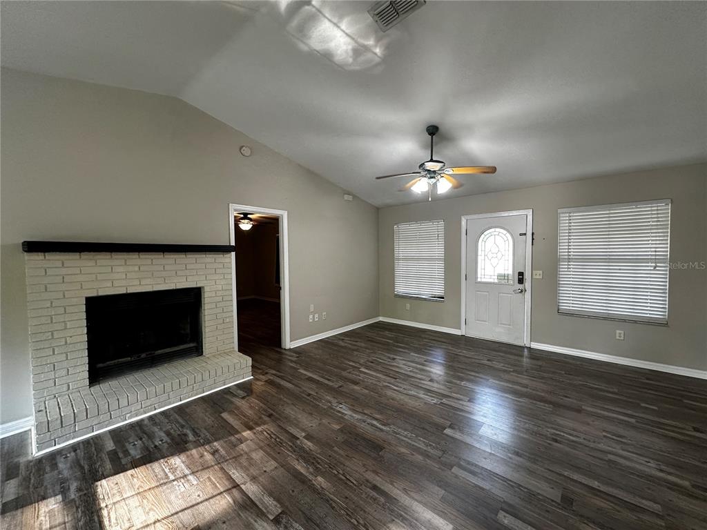44 Teak Road Ocala, FL 34472 - Photo 3 of 12 a view of an empty room with wooden floor fireplace and a window