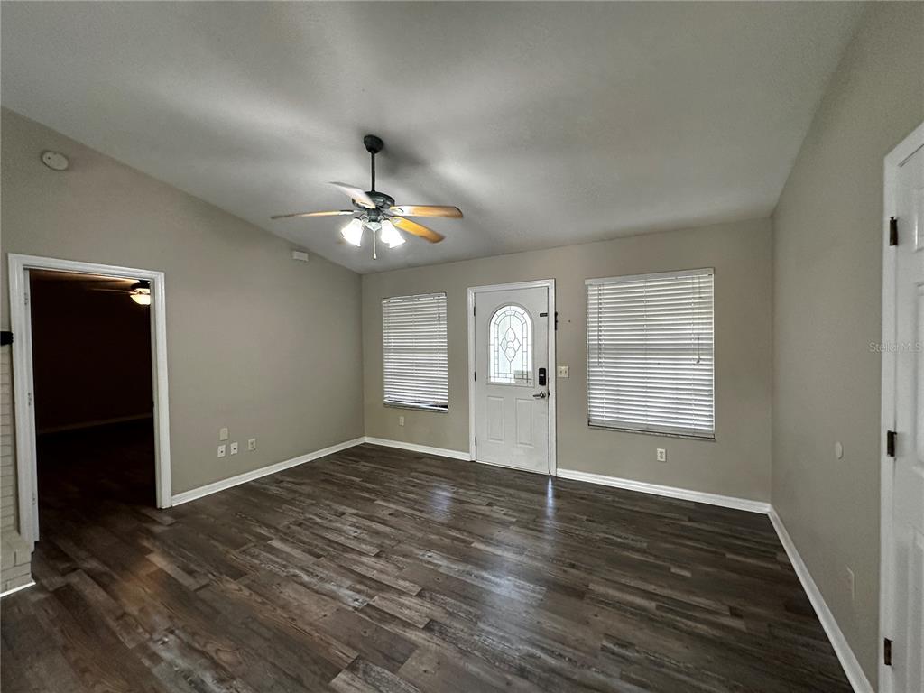 44 Teak Road Ocala, FL 34472 - Photo 8 of 12 an empty room with wooden floor chandelier and windows