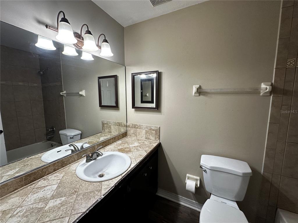44 Teak Road Ocala, FL 34472 - Photo 9 of 12 a bathroom with a sink a toilet a mirror and vanity