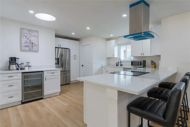 a kitchen with stainless steel appliances a stove a sink a refrigerator and cabinets