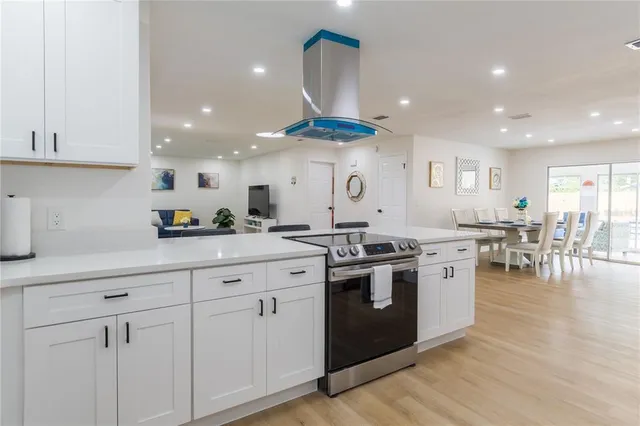 a kitchen with stainless steel appliances granite countertop a lot of counter space and wooden floors