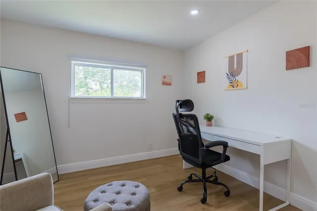 a view of a workspace with furniture and a window