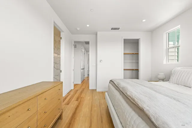 a spacious bedroom with a bed and a dresser