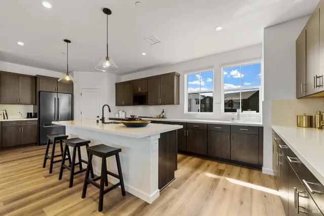 a kitchen with stainless steel appliances kitchen island granite countertop a sink stove and refrigerator