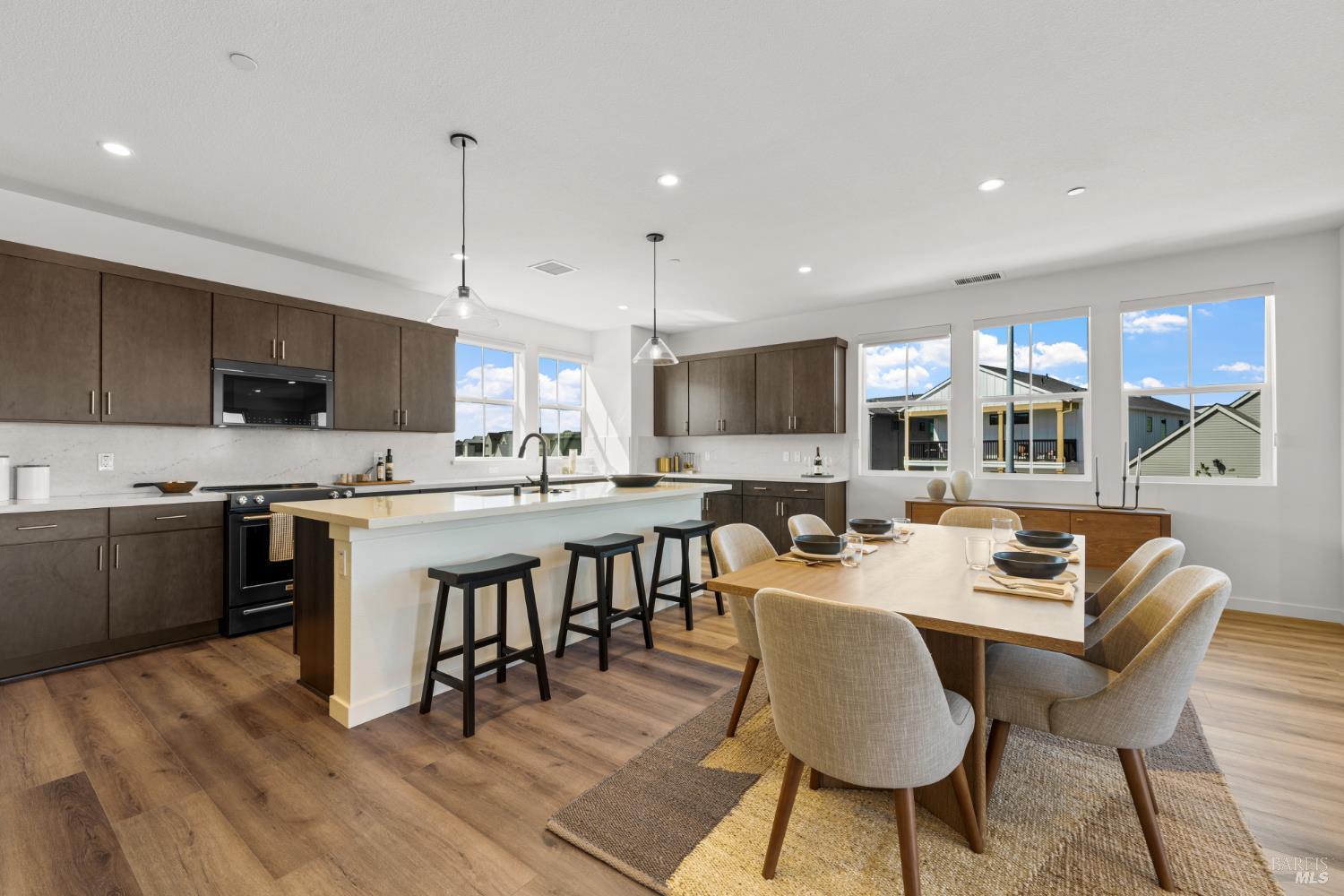 1464 Waterside Lane Rohnert Park, CA 94928 - Photo 8 of 24 a large kitchen with kitchen island a dining table chairs and a stove top oven