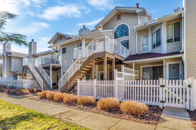 a view of a white house with iron fence