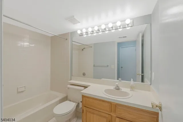 a bathroom with a sink a toilet and a large mirror