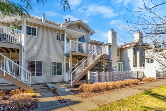 a view of a house with wooden stairs and a small yard
