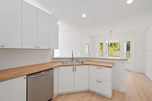 a kitchen with white cabinets and a window
