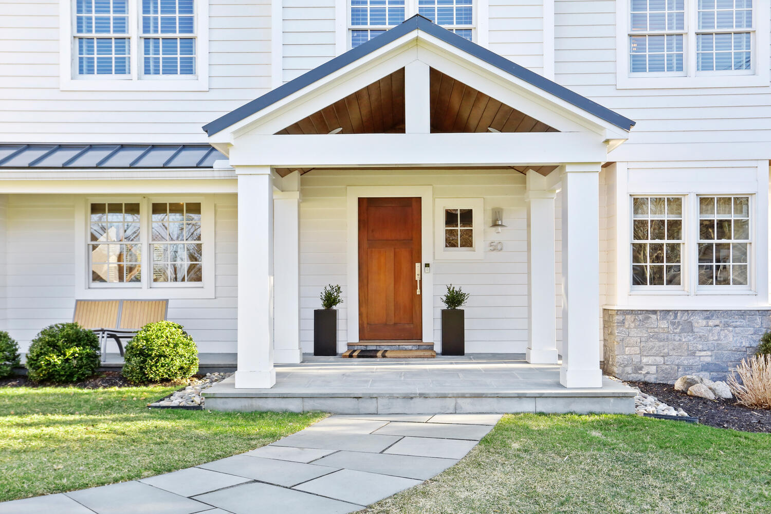 50 Summit Ridge Road New Canaan, CT 06840 - Photo 2 of 49 a view of a brick house with small yard plants and large tree
