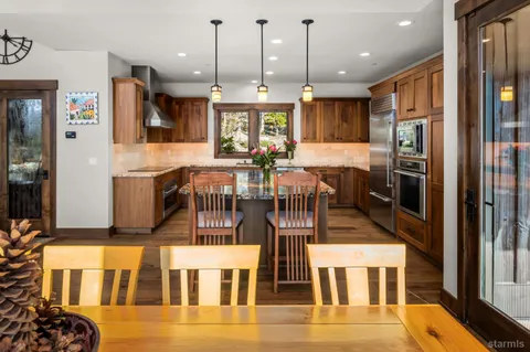 a kitchen with stainless steel appliances granite countertop a stove and a wooden cabinets