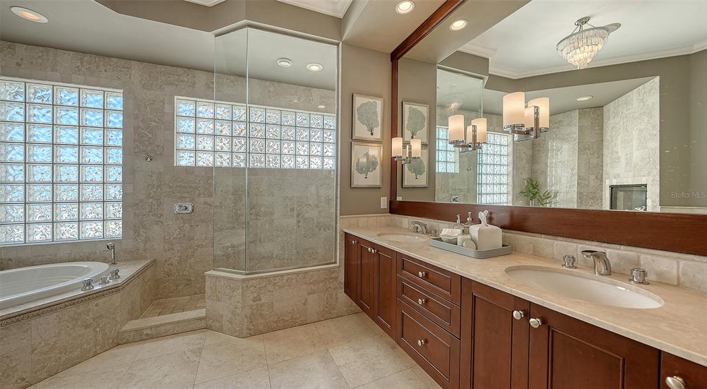 6477 Gulfside Road Longboat Key, FL 34228 - Photo 12 of 65 a bathroom with a granite countertop tub a sink and a large mirror