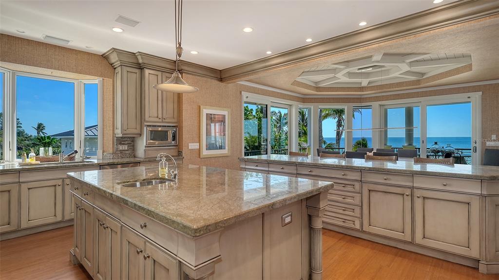 6477 Gulfside Road Longboat Key, FL 34228 - Photo 20 of 65 a large kitchen with granite countertop a sink and white cabinets with wooden floor