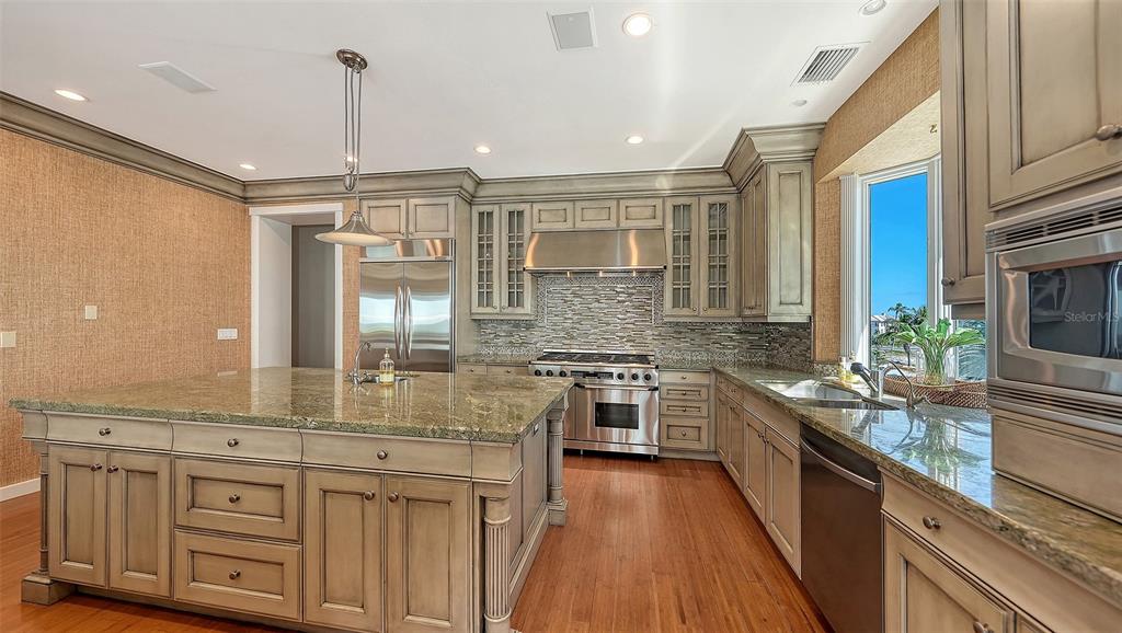 6477 Gulfside Road Longboat Key, FL 34228 - Photo 22 of 65 a kitchen with stainless steel appliances granite countertop a stove a sink and a refrigerator