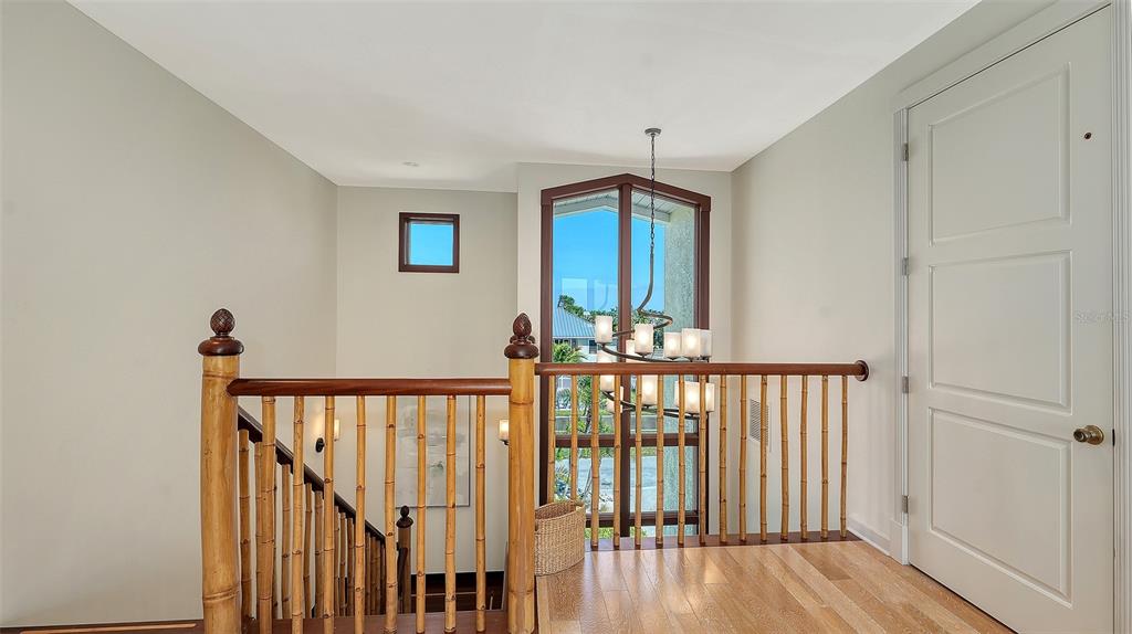 6477 Gulfside Road Longboat Key, FL 34228 - Photo 41 of 65 a view of a hallway with wooden floor and staircase