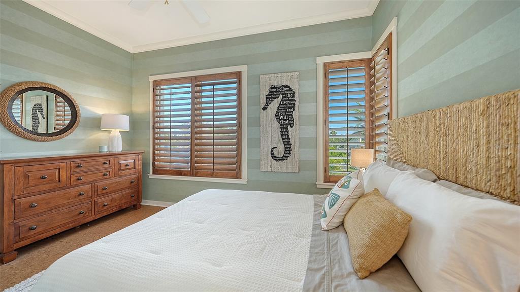 6477 Gulfside Road Longboat Key, FL 34228 - Photo 46 of 65 a bedroom with a bed a mirror and a window
