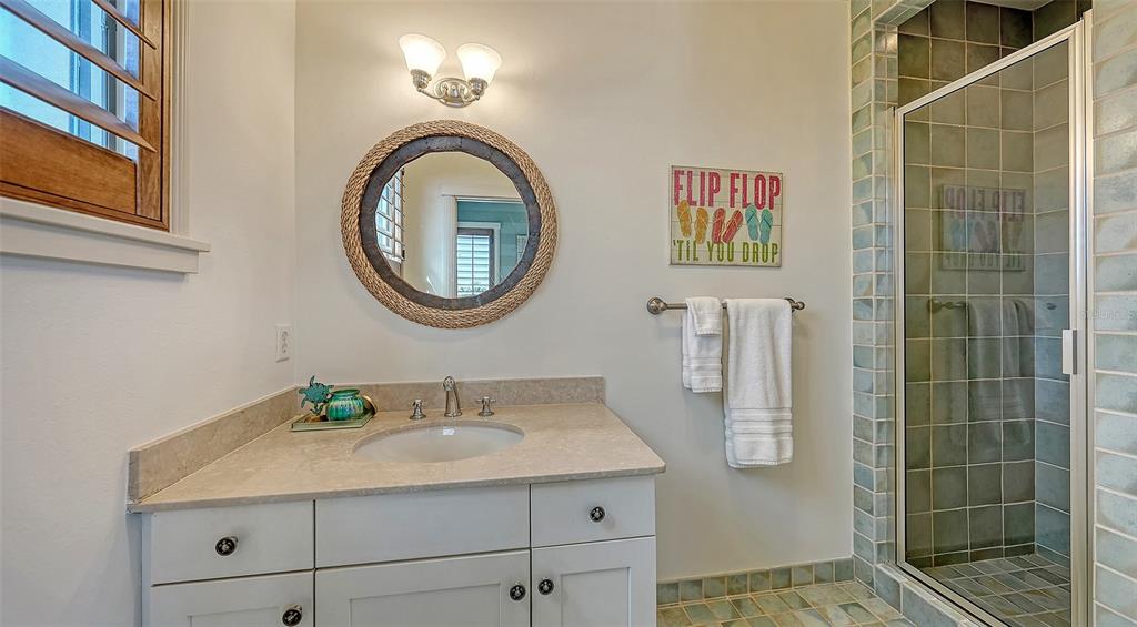 6477 Gulfside Road Longboat Key, FL 34228 - Photo 47 of 65 a bathroom with a granite countertop sink and a mirror